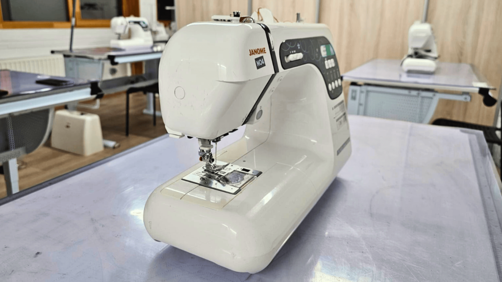Machine à coudre JANOME sur une table dans un atelier de couture
